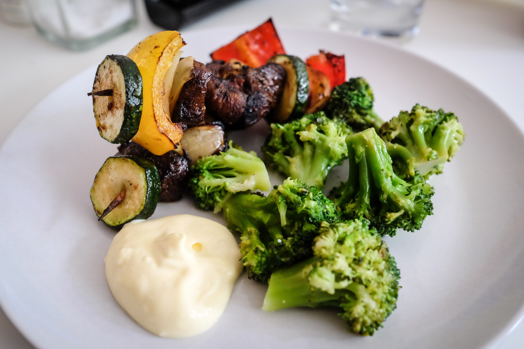 Grillspett med squash, lök och paprika serveras med broccoli och aioli